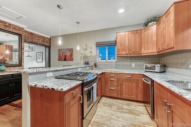 kitchen featuring a sink, a peninsula, tasteful backsplash, light wood finished floors, and appliances with stainless steel finishes