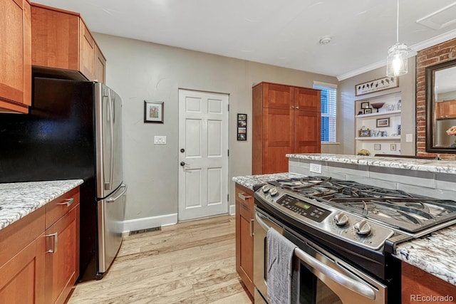 kitchen featuring brown cabinets, light wood-type flooring, decorative light fixtures, appliances with stainless steel finishes, and light stone counters