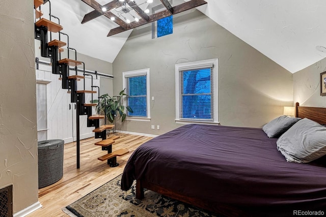 bedroom with wood finished floors and lofted ceiling