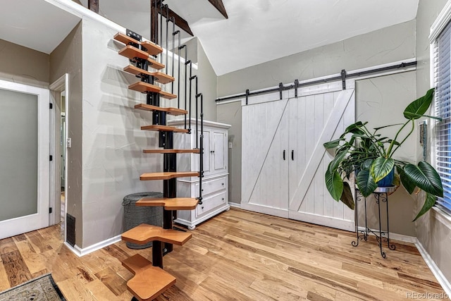 interior space with a barn door and wood finished floors