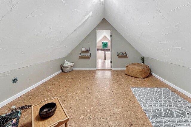 additional living space with vaulted ceiling and baseboards