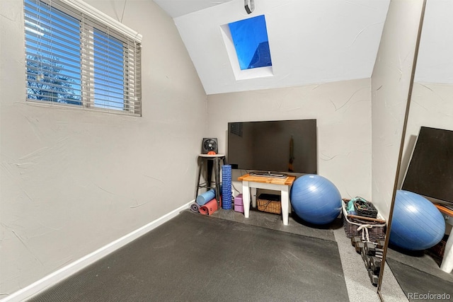 exercise area with vaulted ceiling with skylight and carpet floors
