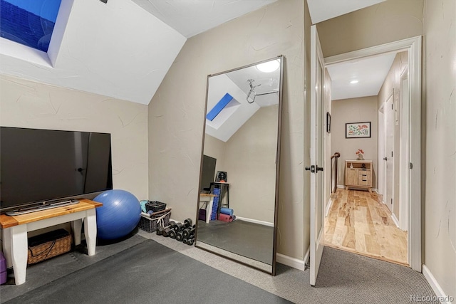 workout area with lofted ceiling and baseboards