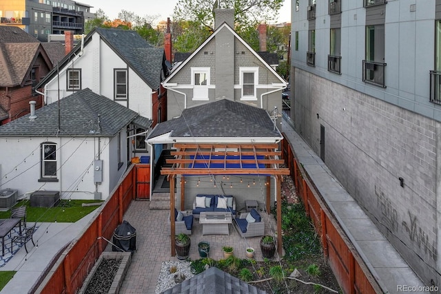 back of house with an outdoor hangout area, a patio, a fenced backyard, and central AC