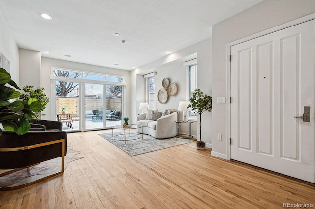 living room featuring recessed lighting, light wood-style floors, and baseboards