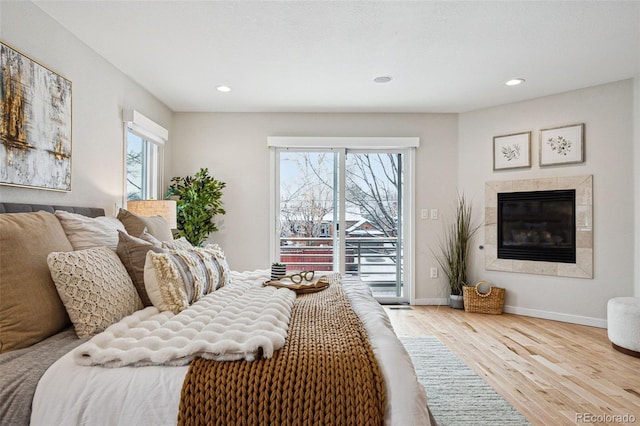 467 Harrison St, Denver, CO 80206 - bedroom with access to exterior, wood finished floors, recessed lighting, and a tiled fireplace