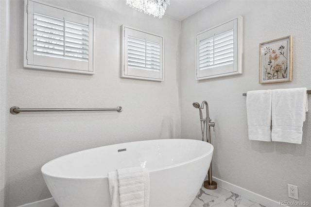 467 Harrison St, Denver, CO 80206 - full bathroom with marble look tiles, a freestanding bath, and a chandelier