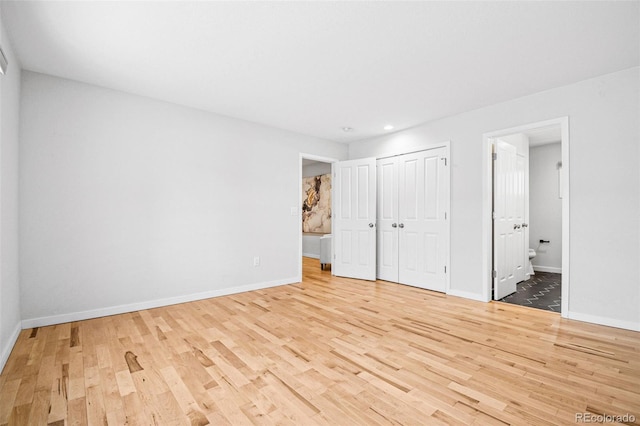 467 Harrison St, Denver, CO 80206 - unfurnished bedroom with light wood finished floors, recessed lighting, ensuite bathroom, and a closet