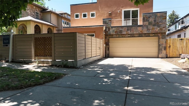 467 Harrison St, Denver, CO 80206 - view of front facade featuring an attached garage, stucco siding, driveway, and stone siding