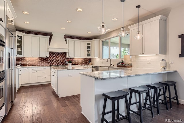 6013 S Kittredge Ct, Centennial, CO 80016 - kitchen with white cabinets, dark wood-style flooring, a peninsula, recessed lighting, and custom range hood
