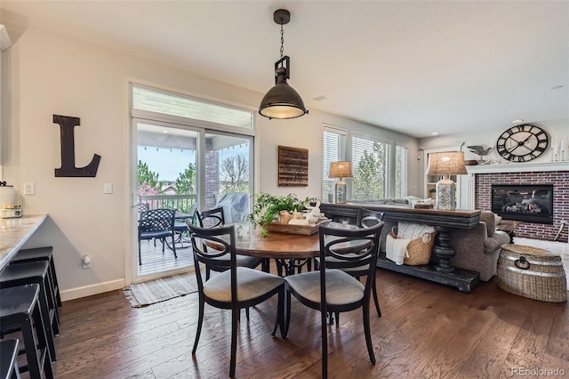 6013 S Kittredge Ct, Centennial, CO 80016 - dining area with a brick fireplace, dark wood-style flooring, and baseboards