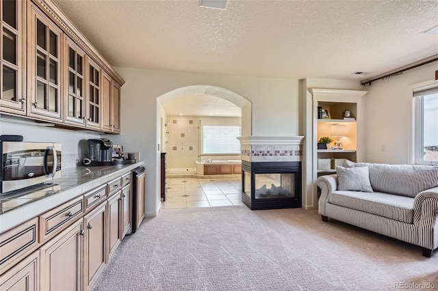 6013 S Kittredge Ct, Centennial, CO 80016 - kitchen with a textured ceiling, visible vents, arched walkways, stainless steel microwave, and tile counters
