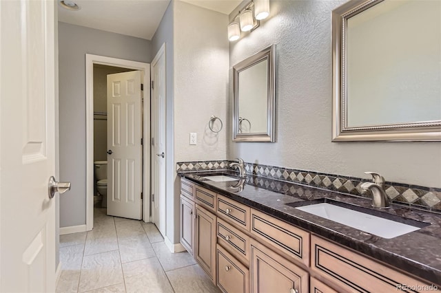 6013 S Kittredge Ct, Centennial, CO 80016 - bathroom with double vanity, toilet, a textured wall, and a sink