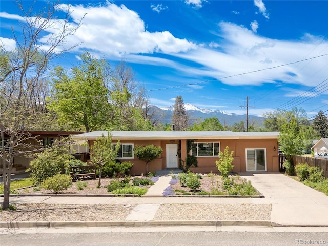 1406 N Foote Ave, Colorado Springs, CO 80909 - ranch-style home featuring a mountain view, driveway, and stucco siding