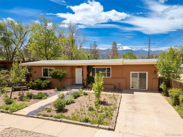1406 N Foote Ave, Colorado Springs, CO 80909 - ranch-style home with a mountain view, stucco siding, and concrete driveway