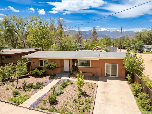 1406 N Foote Ave, Colorado Springs, CO 80909 - ranch-style home with a mountain view, driveway, and stucco siding