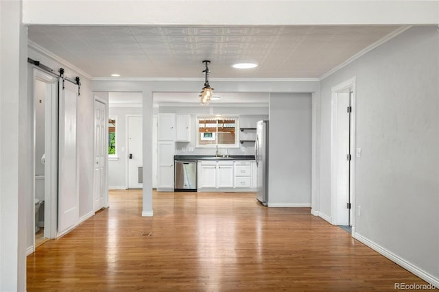 1406 N Foote Ave, Colorado Springs, CO 80909 - kitchen featuring stainless steel appliances, light wood-style flooring, white cabinets, dark countertops, and ornamental molding