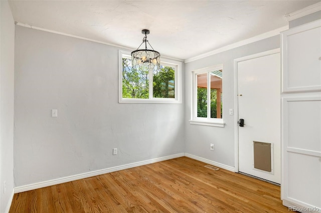 1406 N Foote Ave, Colorado Springs, CO 80909 - unfurnished dining area with plenty of natural light, a chandelier, light wood-style flooring, and crown molding