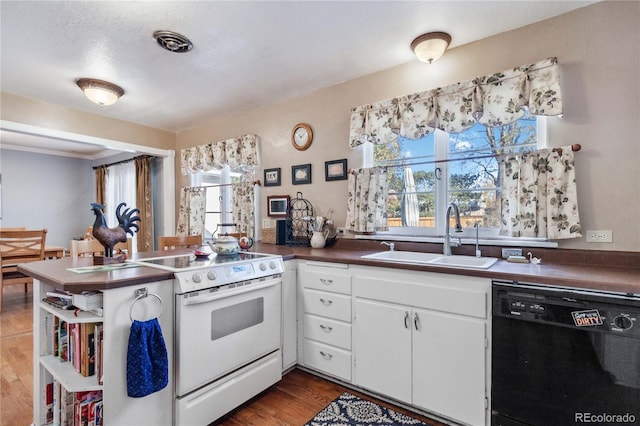 kitchen featuring sink, dishwasher, white range with electric cooktop, white cabinetry, and kitchen peninsula