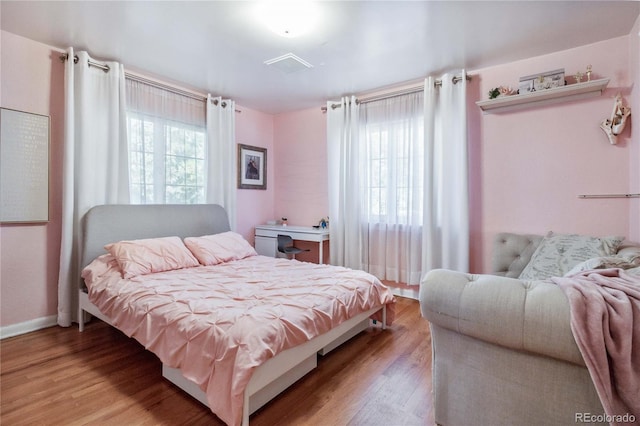 bedroom featuring multiple windows and light wood-type flooring