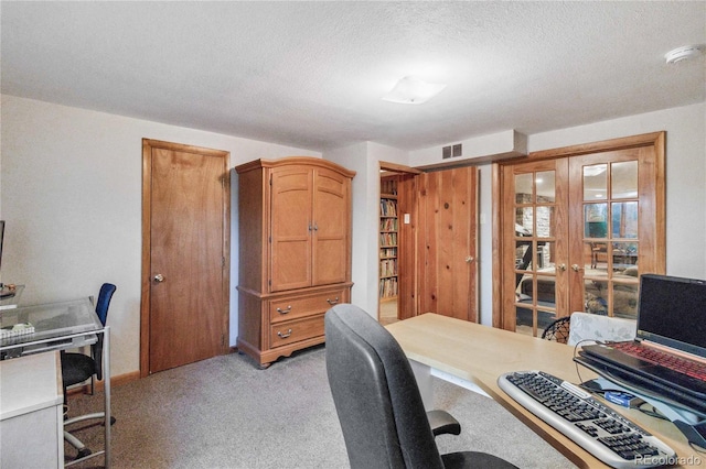 carpeted office space featuring a textured ceiling and french doors