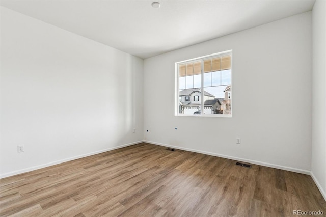 unfurnished room with hardwood / wood-style flooring