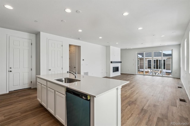 kitchen with white cabinetry, a kitchen island with sink, dishwasher, and sink