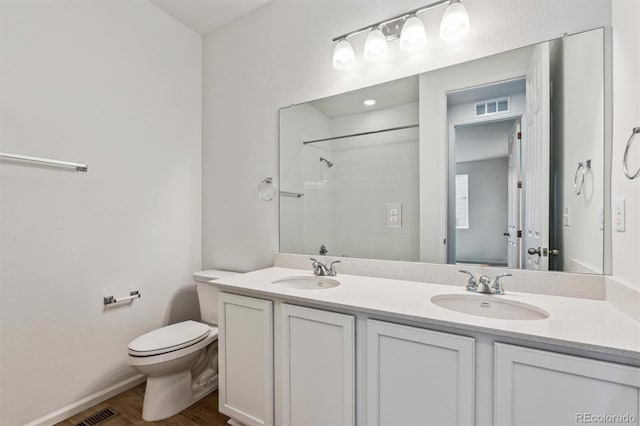 bathroom with vanity, wood-type flooring, toilet, and walk in shower