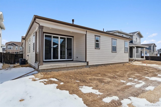 snow covered rear of property with central air condition unit