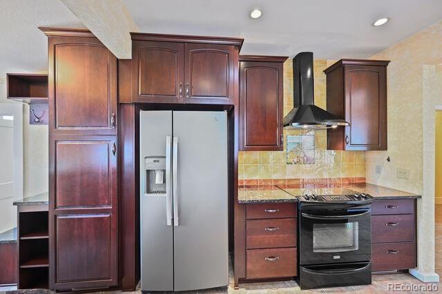 321 S Gilpin St, Denver, CO 80209 - kitchen featuring stainless steel fridge, wall chimney range hood, black electric range, decorative backsplash, and reddish brown cabinets
