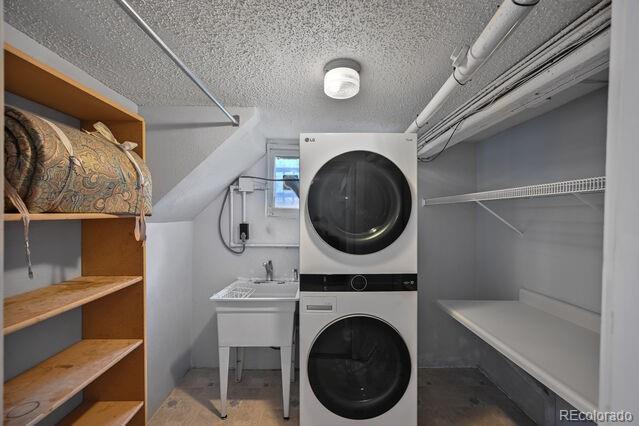 321 S Gilpin St, Denver, CO 80209 - laundry area featuring stacked washing machine and dryer and a textured ceiling