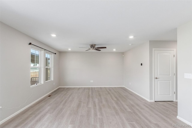 spare room featuring light wood-type flooring, baseboards, a ceiling fan, and recessed lighting