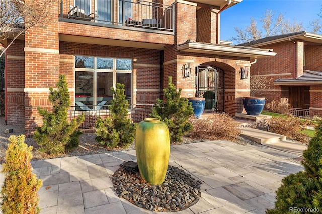 doorway to property with a balcony and a patio