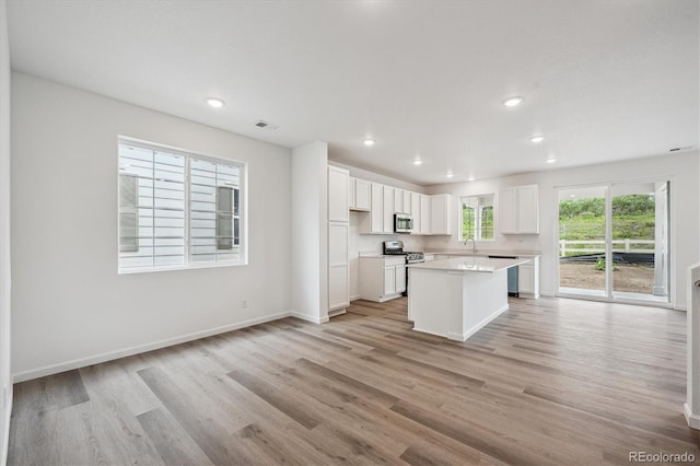 4246 Graywood Dr, Johnstown, CO 80534 - kitchen with stainless steel appliances, white cabinets, light wood finished floors, light countertops, and recessed lighting