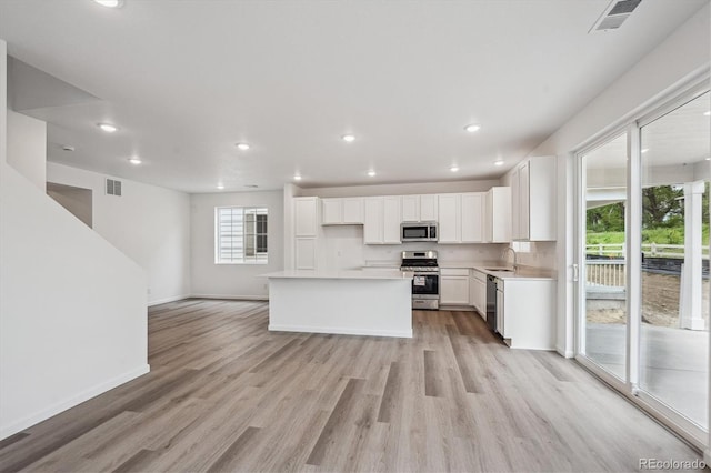 4246 Graywood Dr, Johnstown, CO 80534 - kitchen featuring appliances with stainless steel finishes, light wood-style flooring, a sink, white cabinets, and light countertops