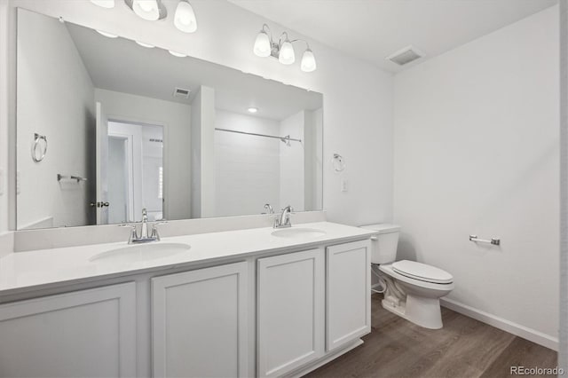 4246 Graywood Dr, Johnstown, CO 80534 - bathroom featuring wood finished floors, toilet, double vanity, a shower, and baseboards