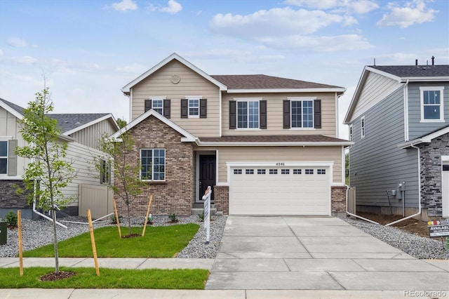 4246 Graywood Dr, Johnstown, CO 80534 - view of front of property featuring brick siding, driveway, an attached garage, and roof with shingles