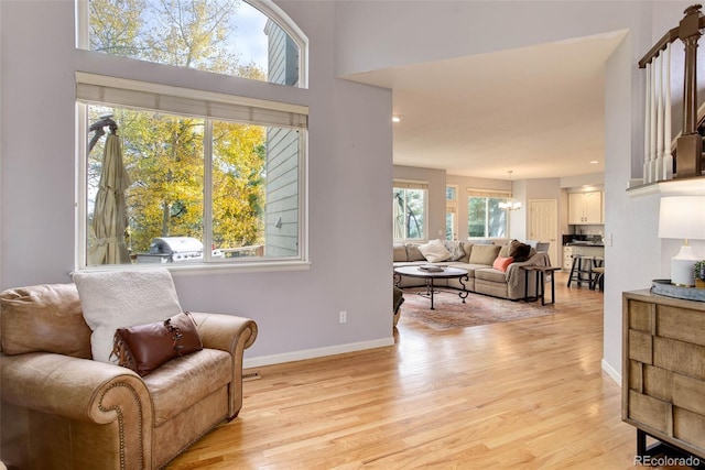 living area with light hardwood / wood-style floors and an inviting chandelier