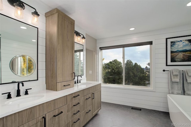 bathroom with vanity, a tub to relax in, wood walls, and tile patterned floors