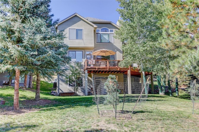 rear view of house with a yard and a deck