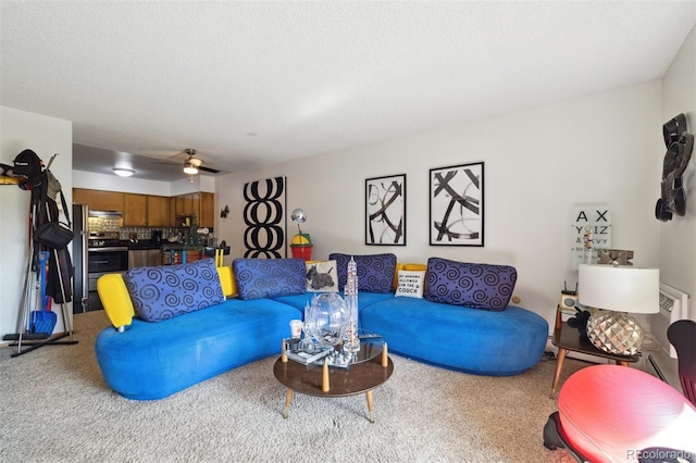 carpeted living room with ceiling fan and a textured ceiling