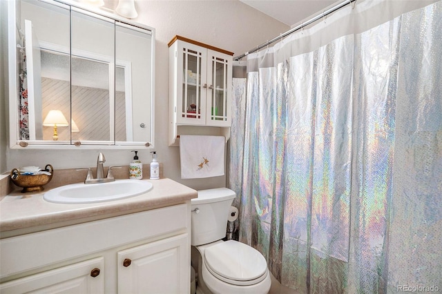 bathroom featuring vanity, toilet, and walk in shower