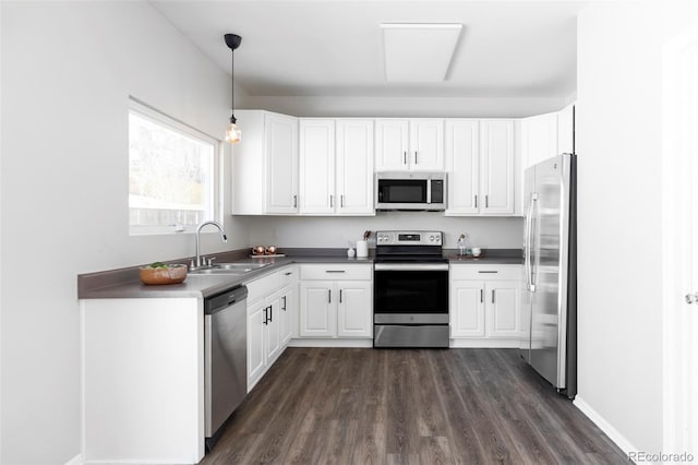 kitchen with sink, white cabinetry, hanging light fixtures, dark hardwood / wood-style flooring, and stainless steel appliances