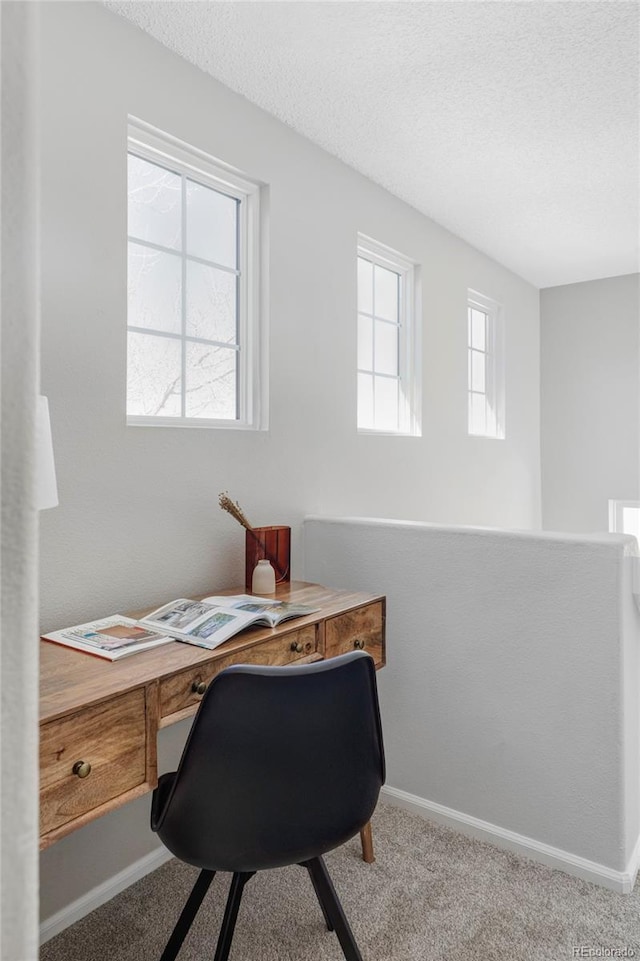 carpeted office featuring a textured ceiling