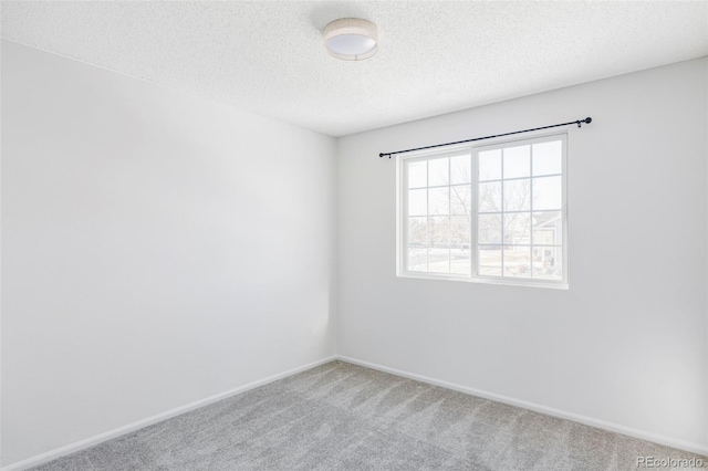 spare room with carpet floors and a textured ceiling