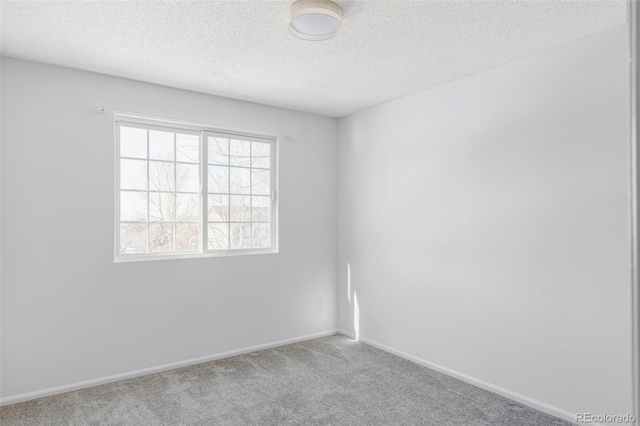 carpeted empty room with a textured ceiling