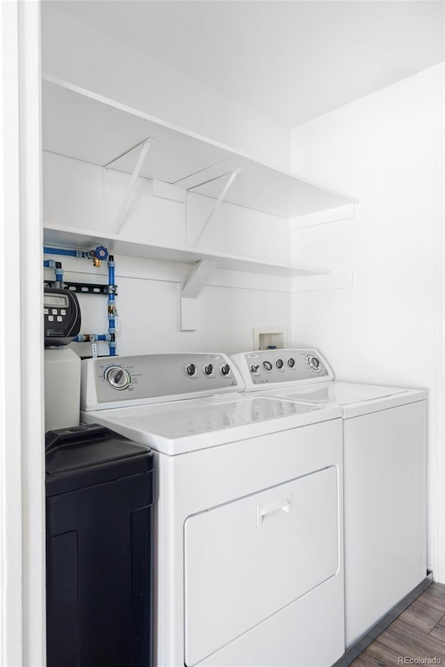 laundry area with dark wood-type flooring and independent washer and dryer