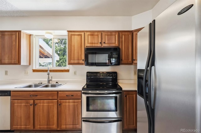 9908 Garfield Ct, Thornton, CO 80229 - kitchen with appliances with stainless steel finishes, a sink, brown cabinetry, and light countertops