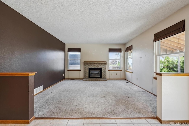 9908 Garfield Ct, Thornton, CO 80229 - unfurnished living room with healthy amount of natural light, carpet, a textured ceiling, and a brick fireplace
