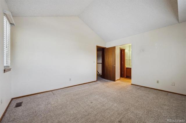 9908 Garfield Ct, Thornton, CO 80229 - spare room featuring light carpet, vaulted ceiling, plenty of natural light, baseboards, and a textured ceiling